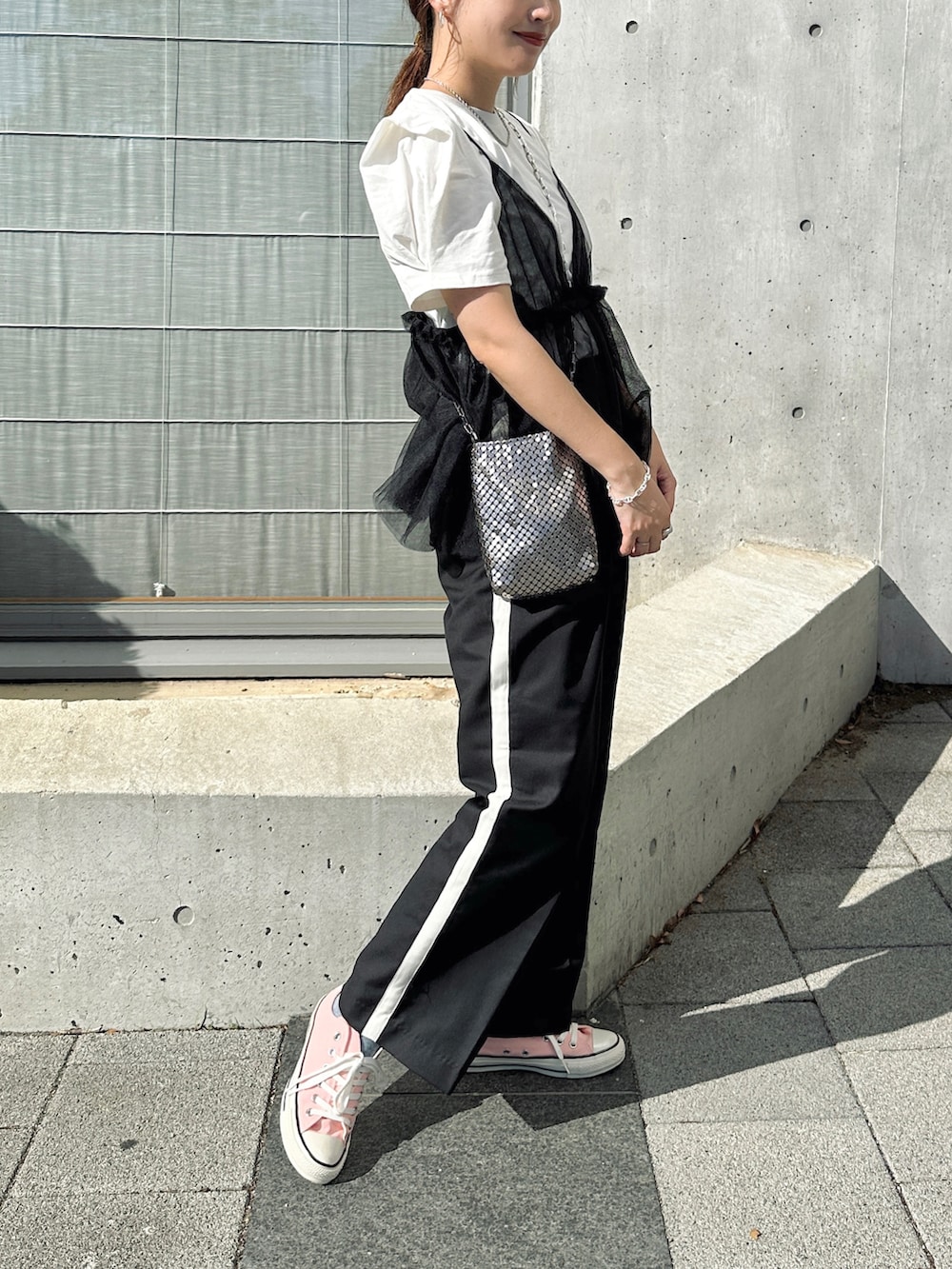 ホワイト系のTシャツ/カットソー、ブラック系のその他パンツ、シルバー系のショルダーバッグを着用したレディースの夏コーディネートの3枚目の写真
