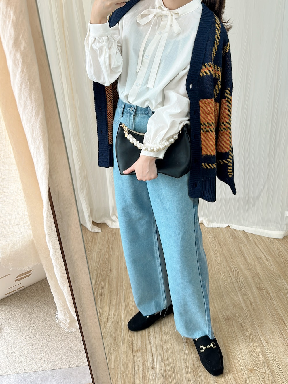 ホワイト系のシャツ/ブラウス、ブルー系のカーディガン/ボレロ、ブルー系のデニムパンツを着用したレディースの秋コーディネートの3枚目の写真