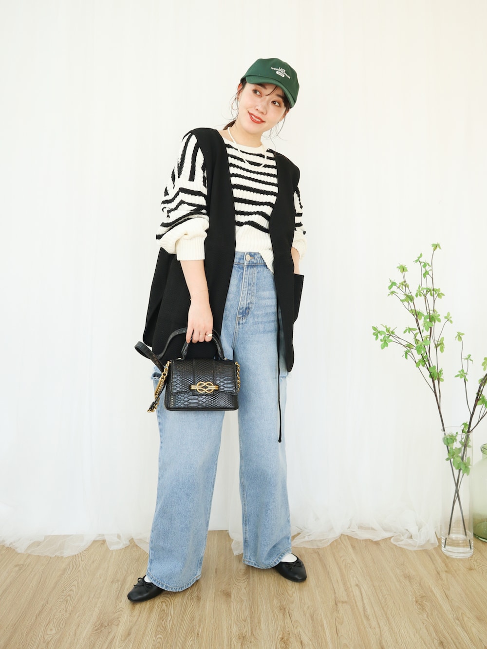 ブルー系のデニムパンツ、ブラック系のバレエシューズ、ブラック系のバッグを着用したレディースの冬コーディネートの3枚目の写真