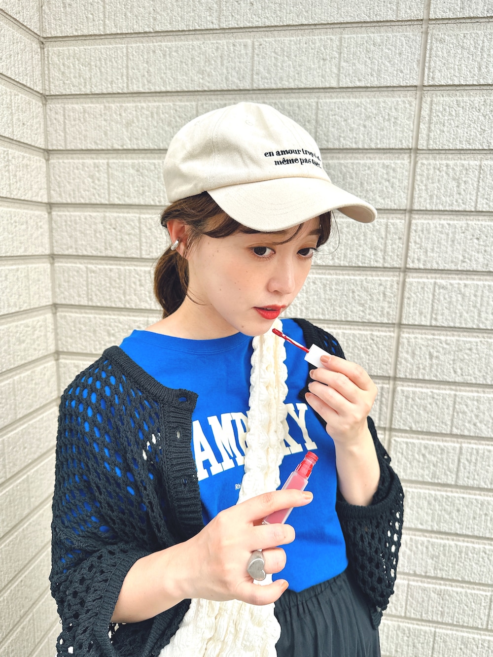 ブルー系のTシャツ/カットソー、ブラック系のスカート、ホワイト系のスニーカーを着用したレディースの春コーディネートの3枚目の写真