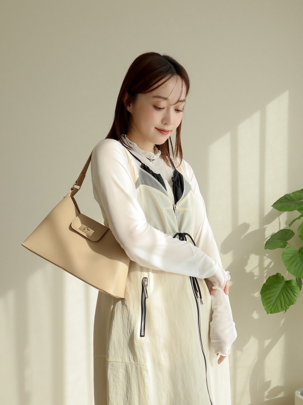 ホワイト系のジャンパースカート、ブルー系のデニムパンツ、シルバー系のパンプスを着用したレディースの冬コーディネートの3枚目の写真