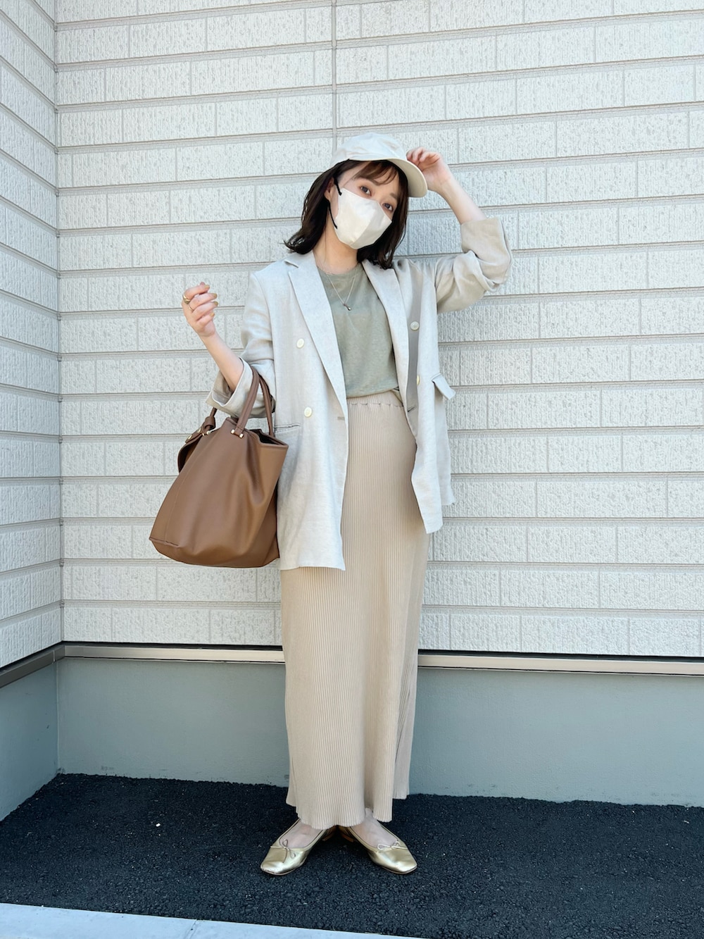 グリーン系のTシャツ/カットソー、ベージュ系のテーラードジャケット、ベージュ系のスカートを着用したレディースの夏コーディネートの2枚目の写真