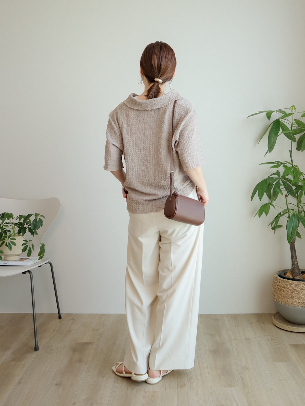 ベージュ系のシャツ/ブラウス、ホワイト系のスラックス、ブラウン系のショルダーバッグを着用したレディースの夏コーディネートの2枚目の写真
