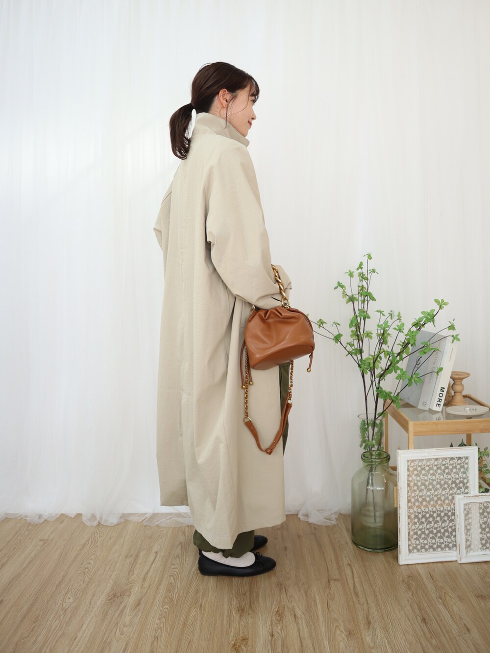 ベージュ系のジャケット/アウター、グリーン系のカーゴパンツ、ブラック系のニット/セーターを着用したレディースの冬コーディネートの2枚目の写真