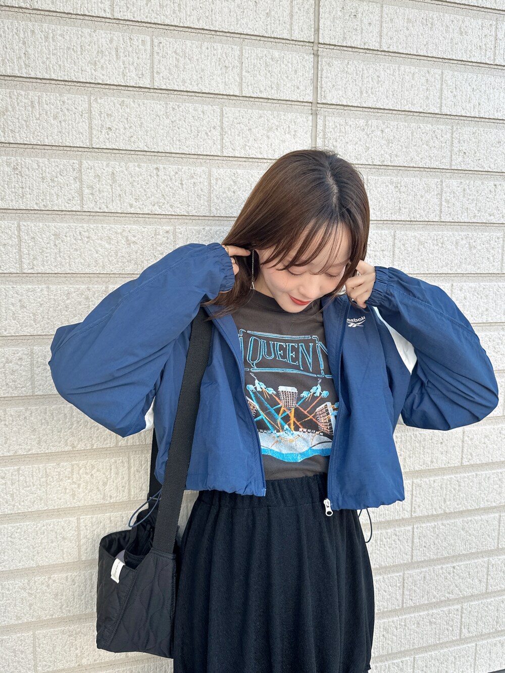 ブラック系のTシャツ/カットソー、ブラック系のスカート、ブラック系のブーツを着用したレディースの秋コーディネートの3枚目の写真