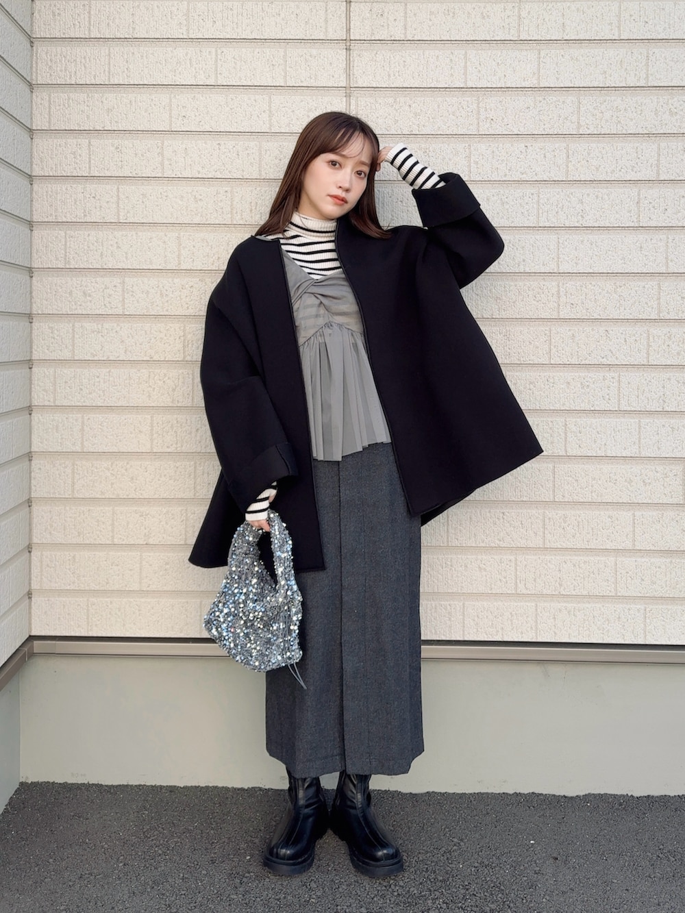 グレー系のキャミソール、グレー系のスカート、ホワイト系のニット/セーターを着用したレディースの冬コーディネートの2枚目の写真