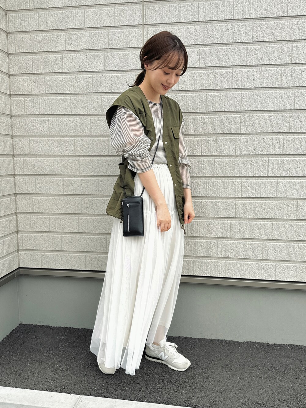 ホワイト系のTシャツ/カットソー、ホワイト系のスカート、ブラック系のショルダーバッグを着用したレディースの春コーディネートの3枚目の写真