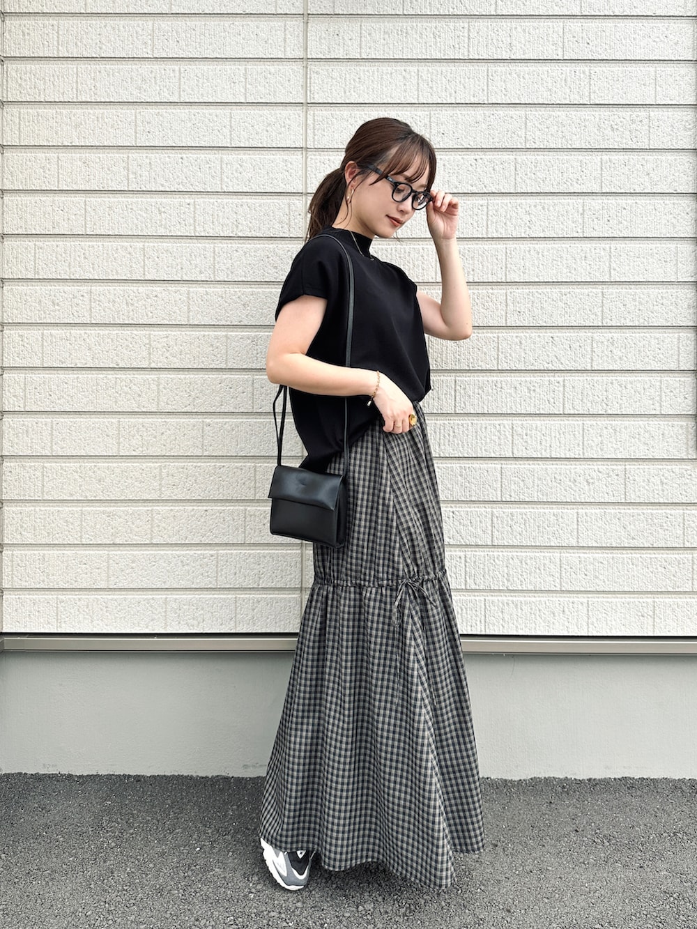 ブラック系のスカート、ブラック系のトップス、ブラック系のショルダーバッグを着用したレディースの夏コーディネートの3枚目の写真