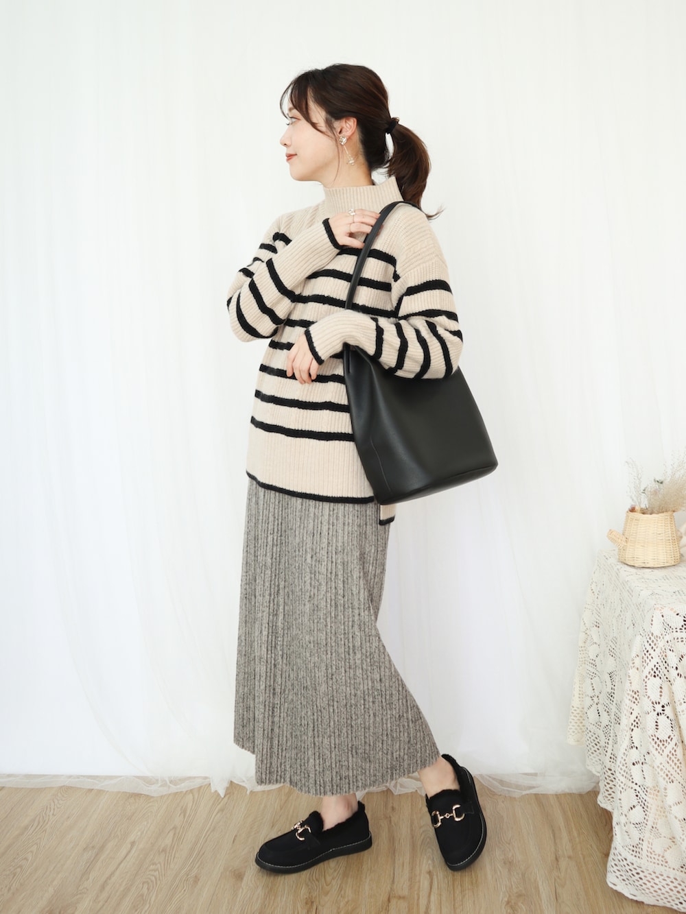 ベージュ系のニット/セーター、ベージュ系のスカート、ブラック系のバッグを着用したレディースの秋コーディネートの3枚目の写真
