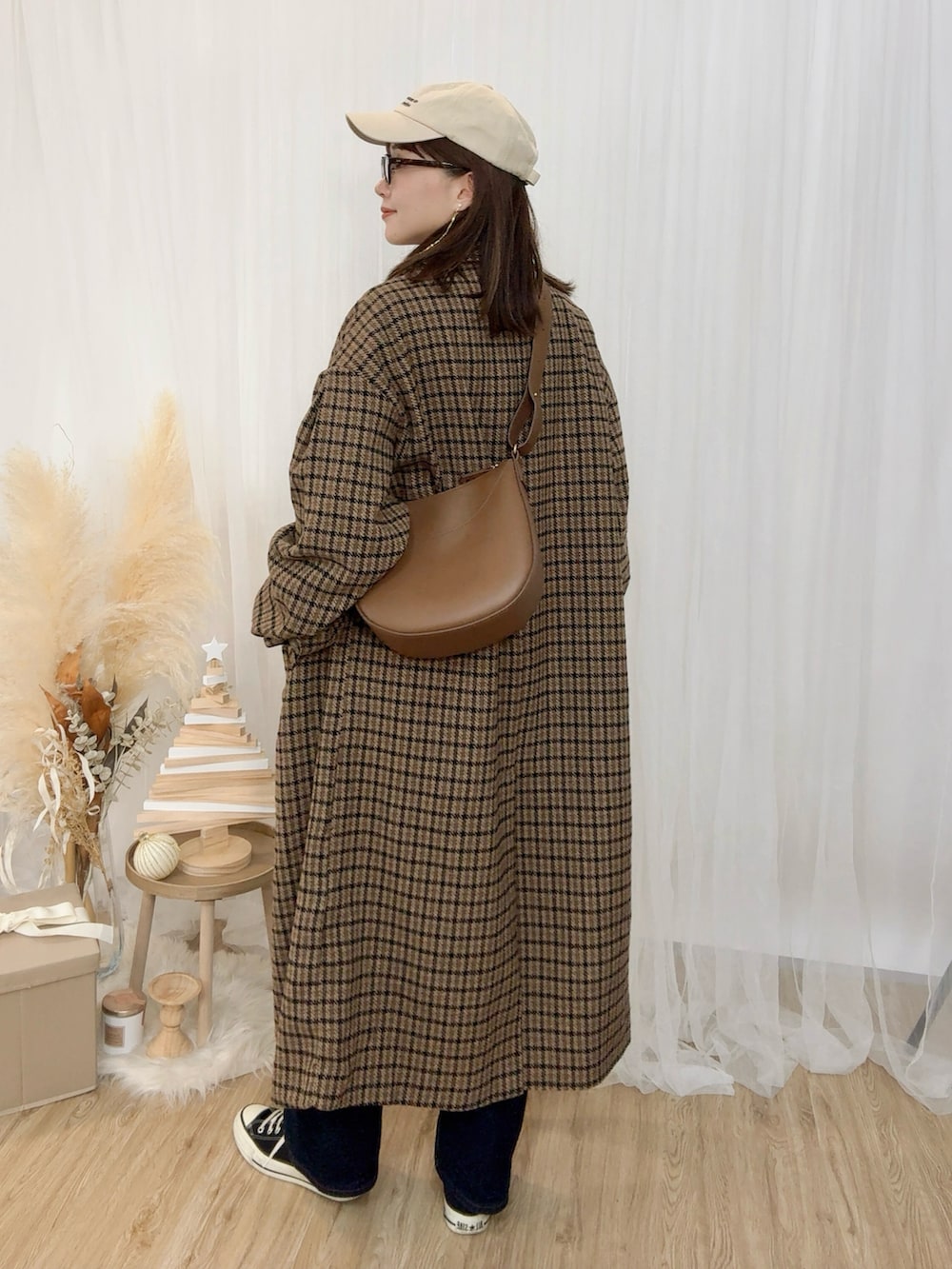 レッド系のニット/セーター、ブルー系のデニムパンツ、ブラウン系のジャケット/アウターを着用したレディースの冬コーディネートの3枚目の写真