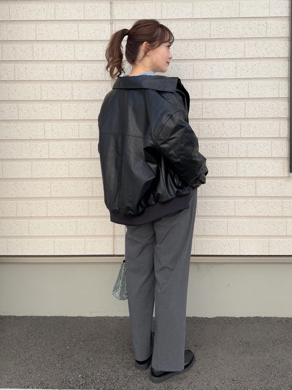 ブルー系のシャツ/ブラウス、ブラック系のジャケット/アウター、グレー系のパンツを着用したレディースの冬コーディネートの2枚目の写真