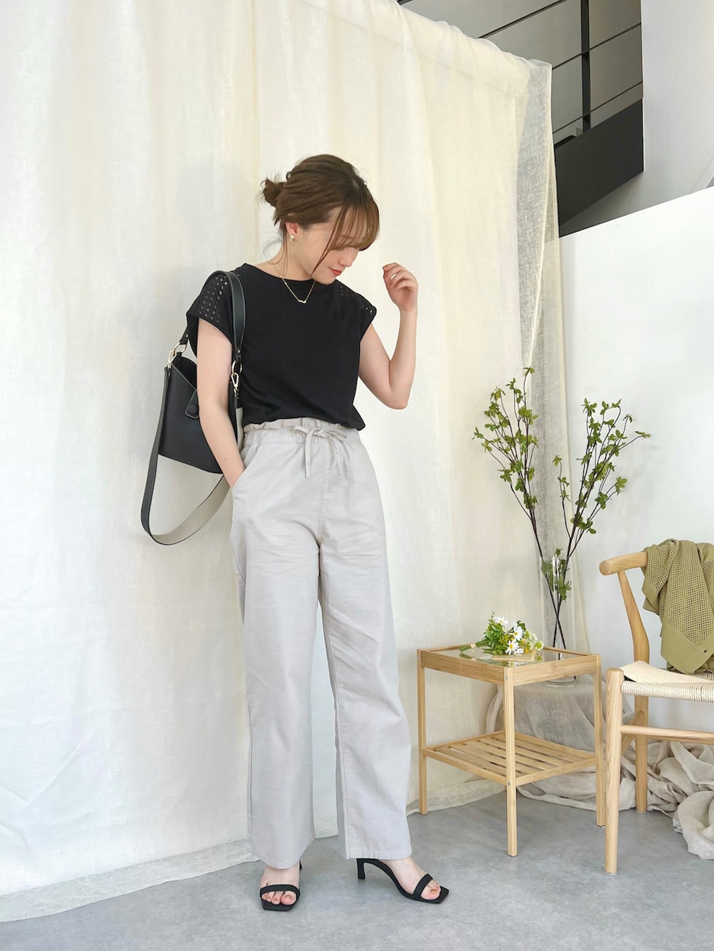 ブラック系のトップス、グリーン系のカーディガン/ボレロ、ベージュ系のパンツを着用したレディースの春コーディネートの3枚目の写真