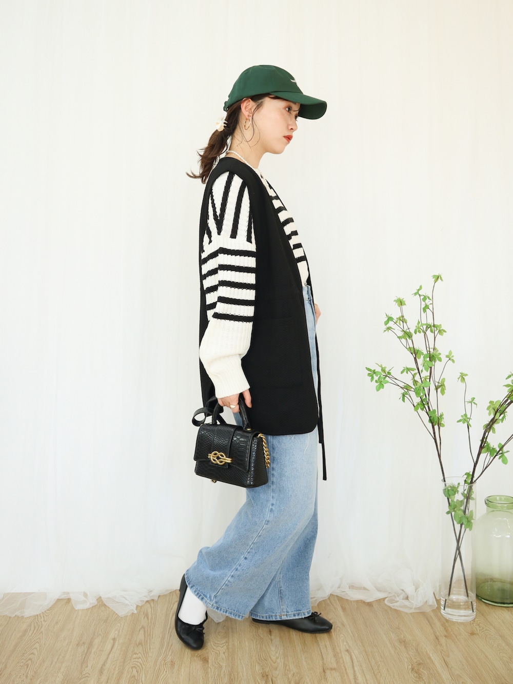 ブルー系のデニムパンツ、ブラック系のバレエシューズ、ブラック系のバッグを着用したレディースの冬コーディネートの4枚目の写真