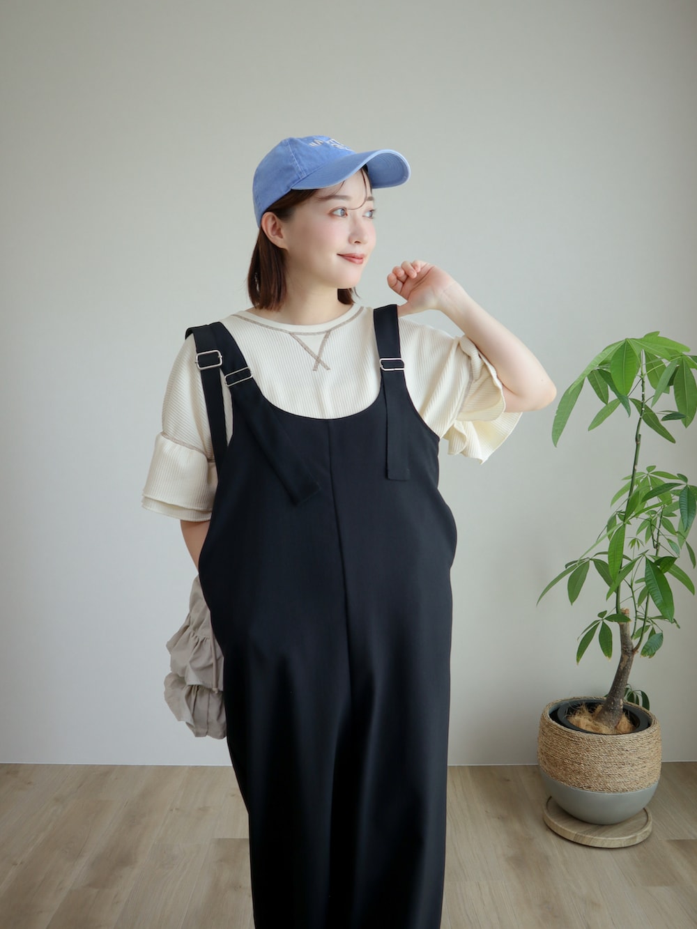 ホワイト系のTシャツ/カットソー、ブラック系のスニーカー、ブラック系のオールインワン・サロペットを着用したレディースの夏コーディネートの2枚目の写真