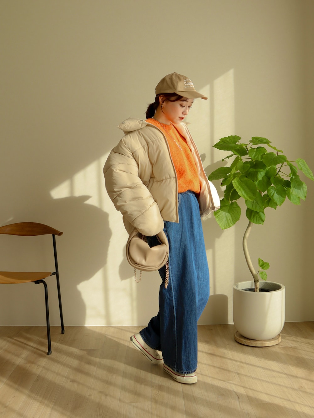 ベージュ系のジャケット/アウター、ベージュ系のハンドバッグ、ブルー系のデニムパンツを着用したレディースの冬コーディネートの3枚目の写真