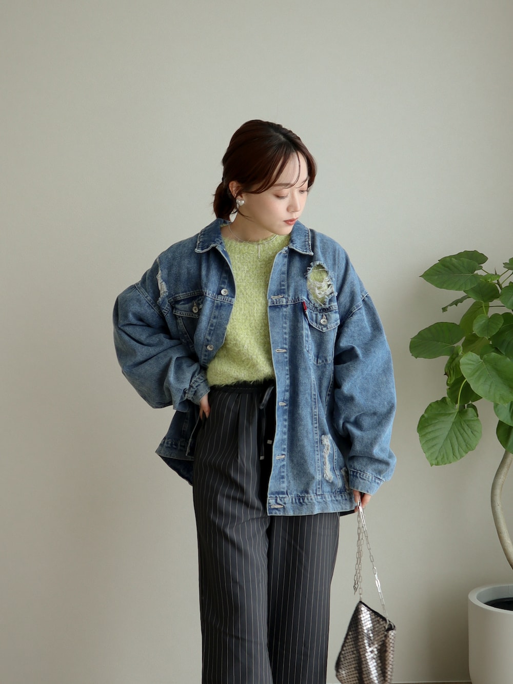 グリーン系のニット/セーター、ブルー系のデニムジャケット、グレー系のパンツを着用したレディースの冬コーディネートの2枚目の写真