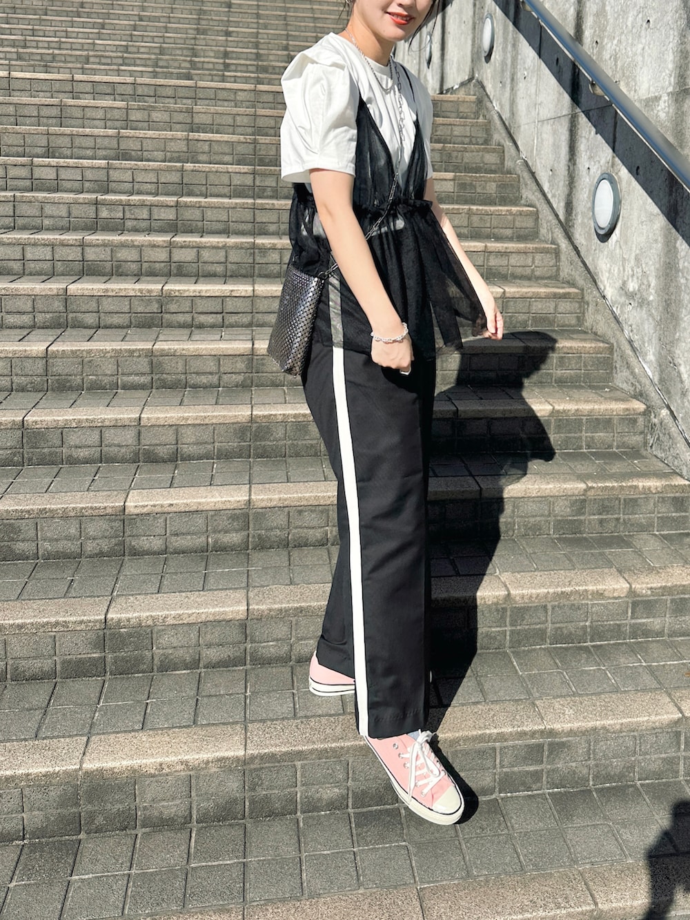 ホワイト系のTシャツ/カットソー、ブラック系のその他パンツ、シルバー系のショルダーバッグを着用したレディースの夏コーディネートの4枚目の写真