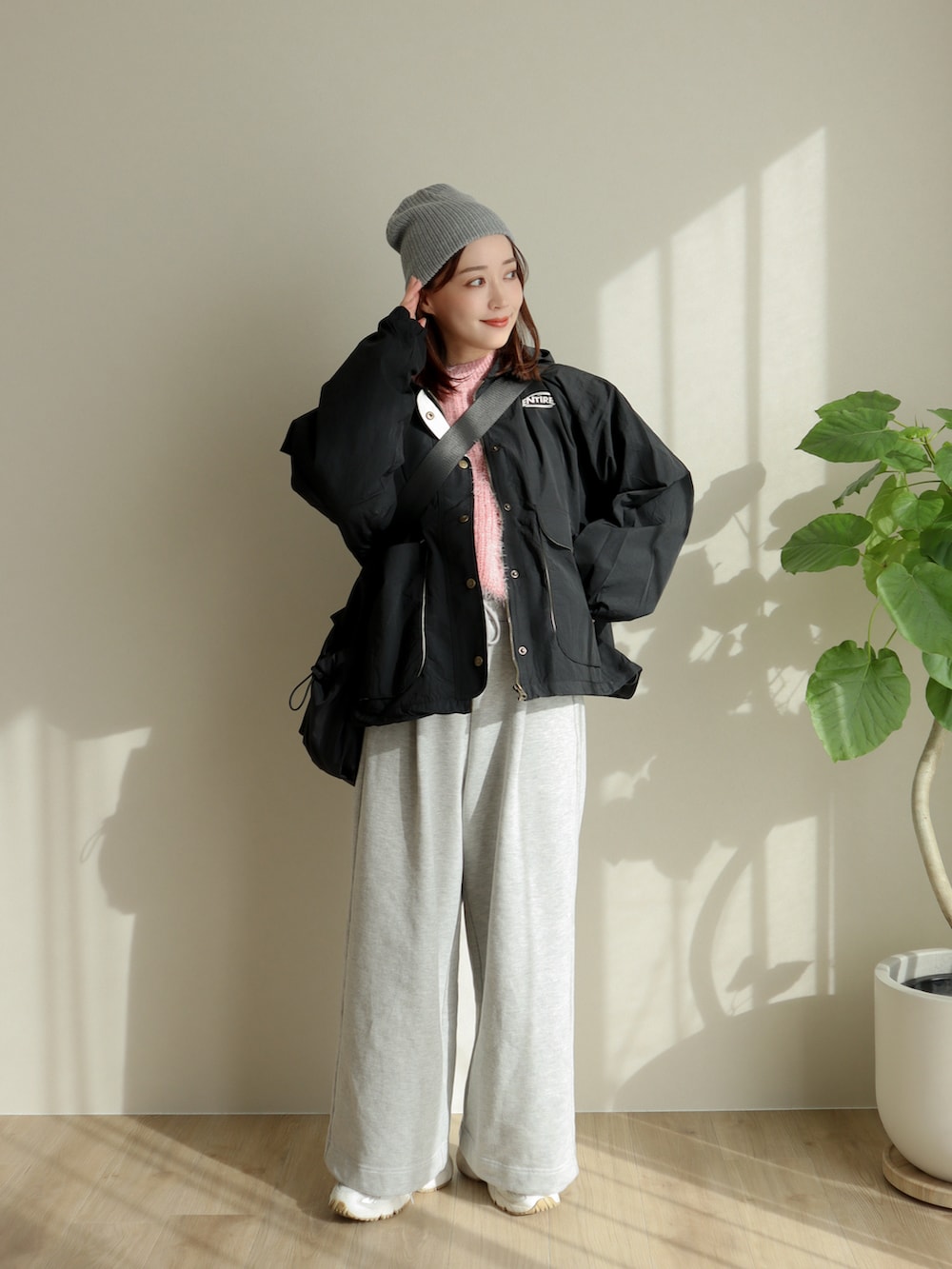 ブラック系のブルゾン、ピンク系のニット/セーター、グレー系のスウェットパンツを着用したレディースの冬コーディネートの2枚目の写真