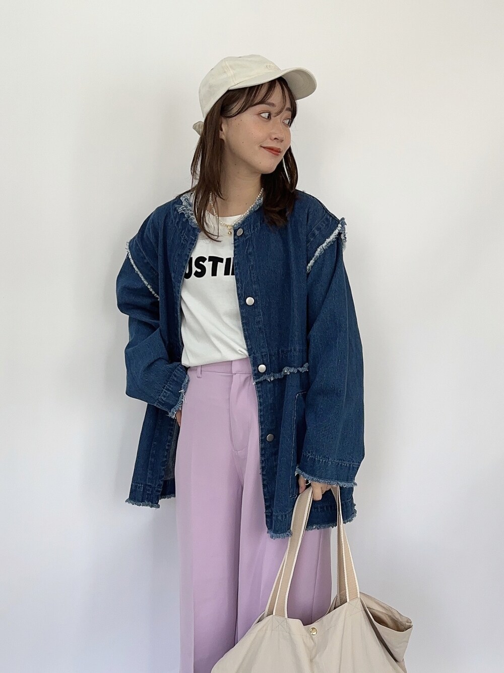 ホワイト系のTシャツ/カットソー、ブルー系のデニムジャケット、ベージュ系のバッグを着用したレディースの春コーディネートの2枚目の写真