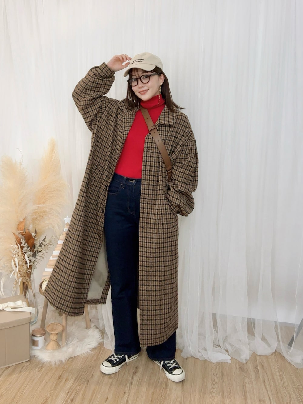 レッド系のニット/セーター、ブルー系のデニムパンツ、ブラウン系のジャケット/アウターを着用したレディースの冬コーディネートの2枚目の写真