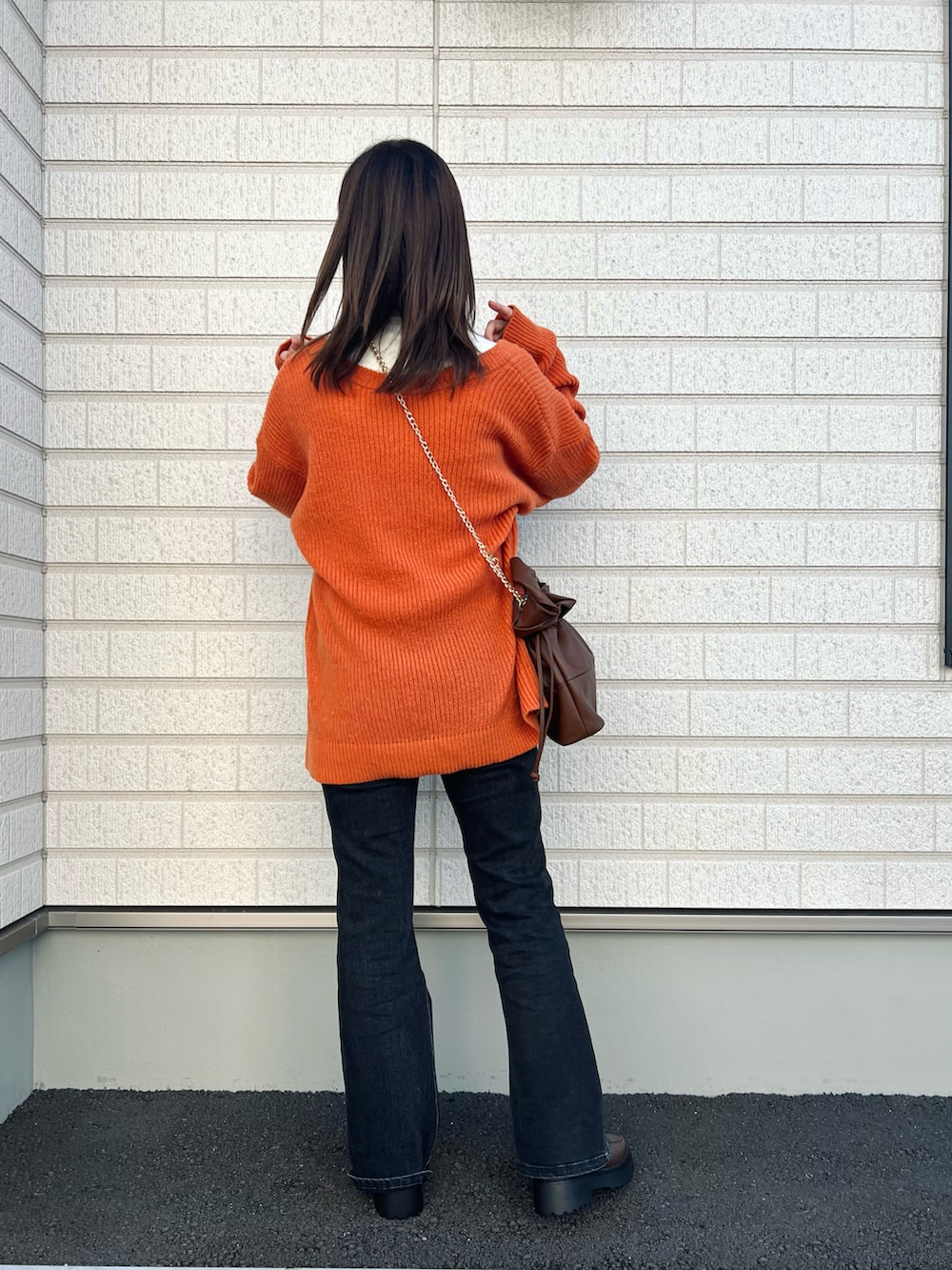 オレンジ系のカーディガン/ボレロ、ホワイト系のTシャツ/カットソー、ブラウン系のバッグを着用したレディースの秋コーディネートの3枚目の写真
