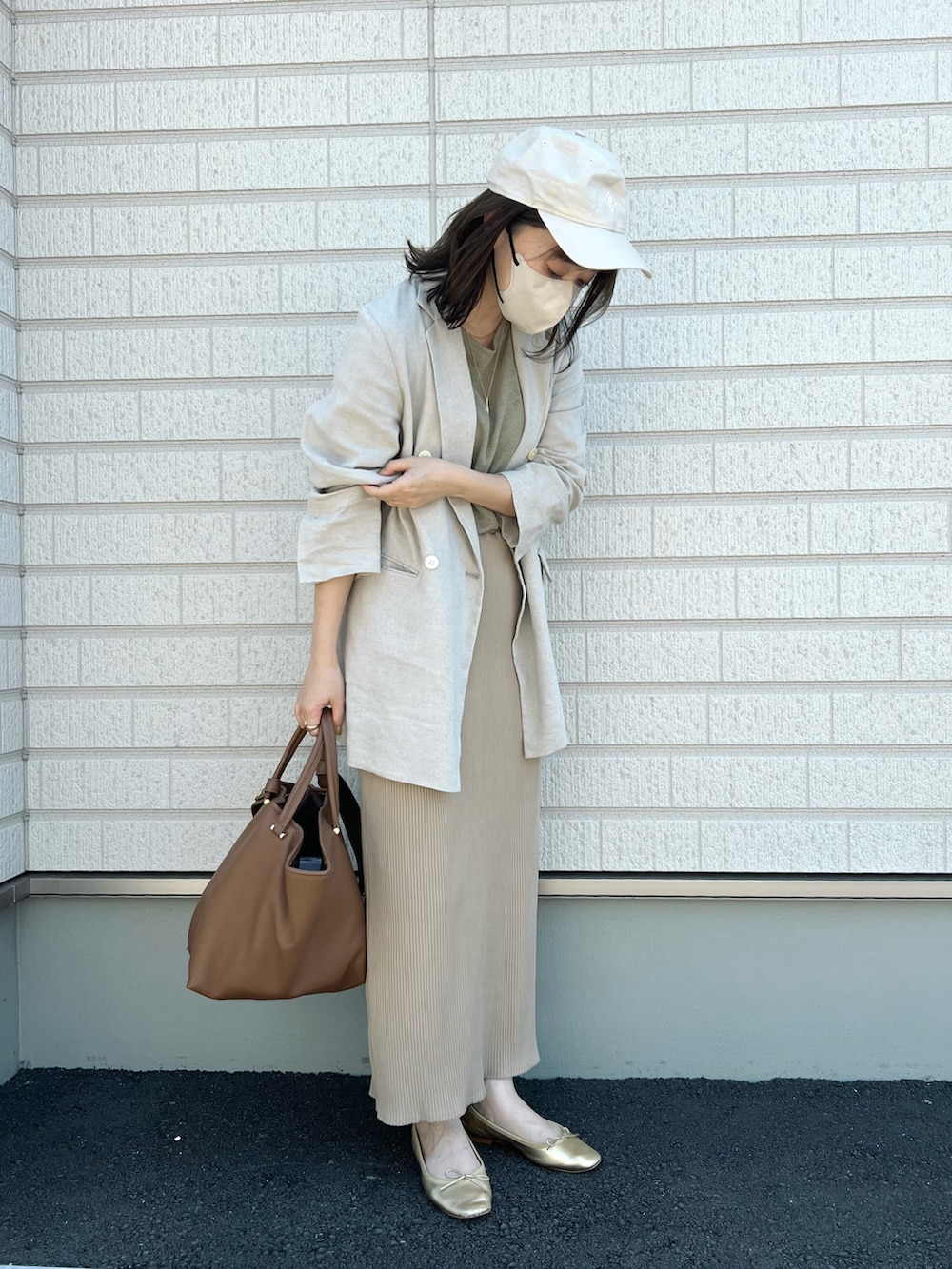 グリーン系のTシャツ/カットソー、ベージュ系のテーラードジャケット、ベージュ系のスカートを着用したレディースの夏コーディネートの3枚目の写真