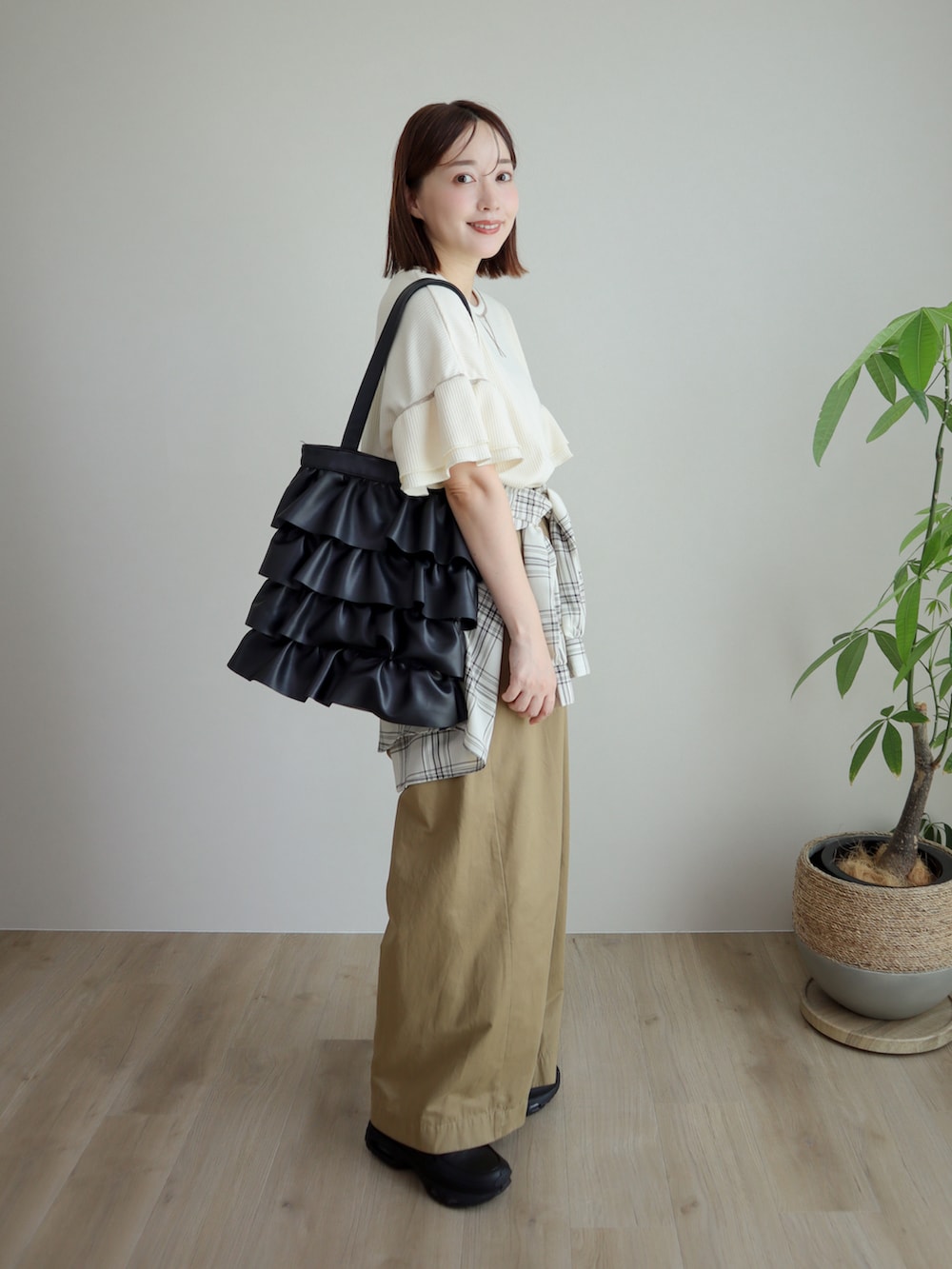ホワイト系のTシャツ/カットソー、ベージュ系のデニムパンツ、ブラック系のスニーカーを着用したレディースの夏コーディネートの2枚目の写真