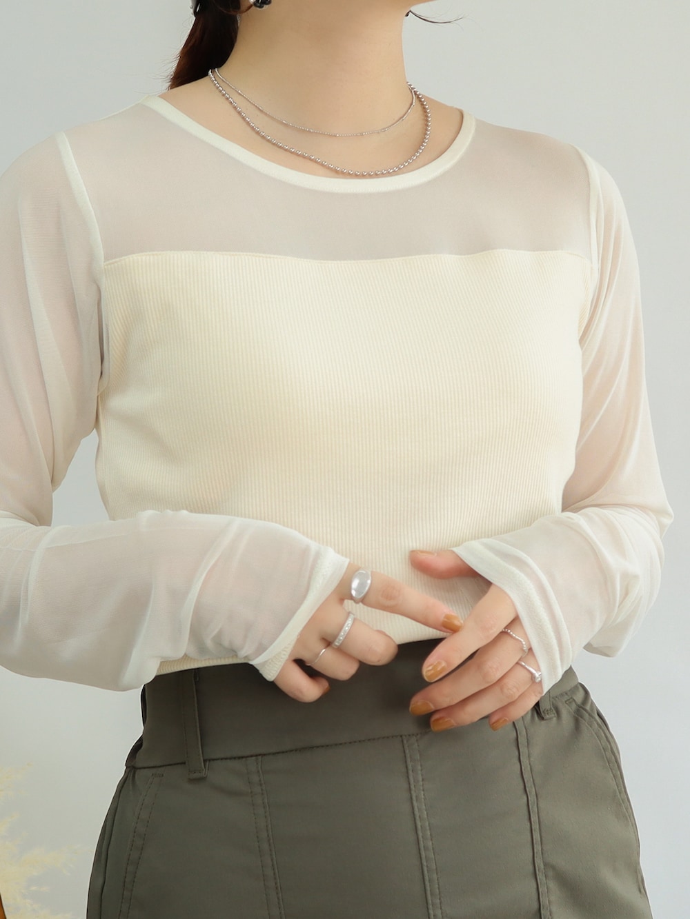 ブラック系のショルダーバッグ、グリーン系のスカート、ブラック系のブーツを着用したレディースの秋コーディネートの3枚目の写真