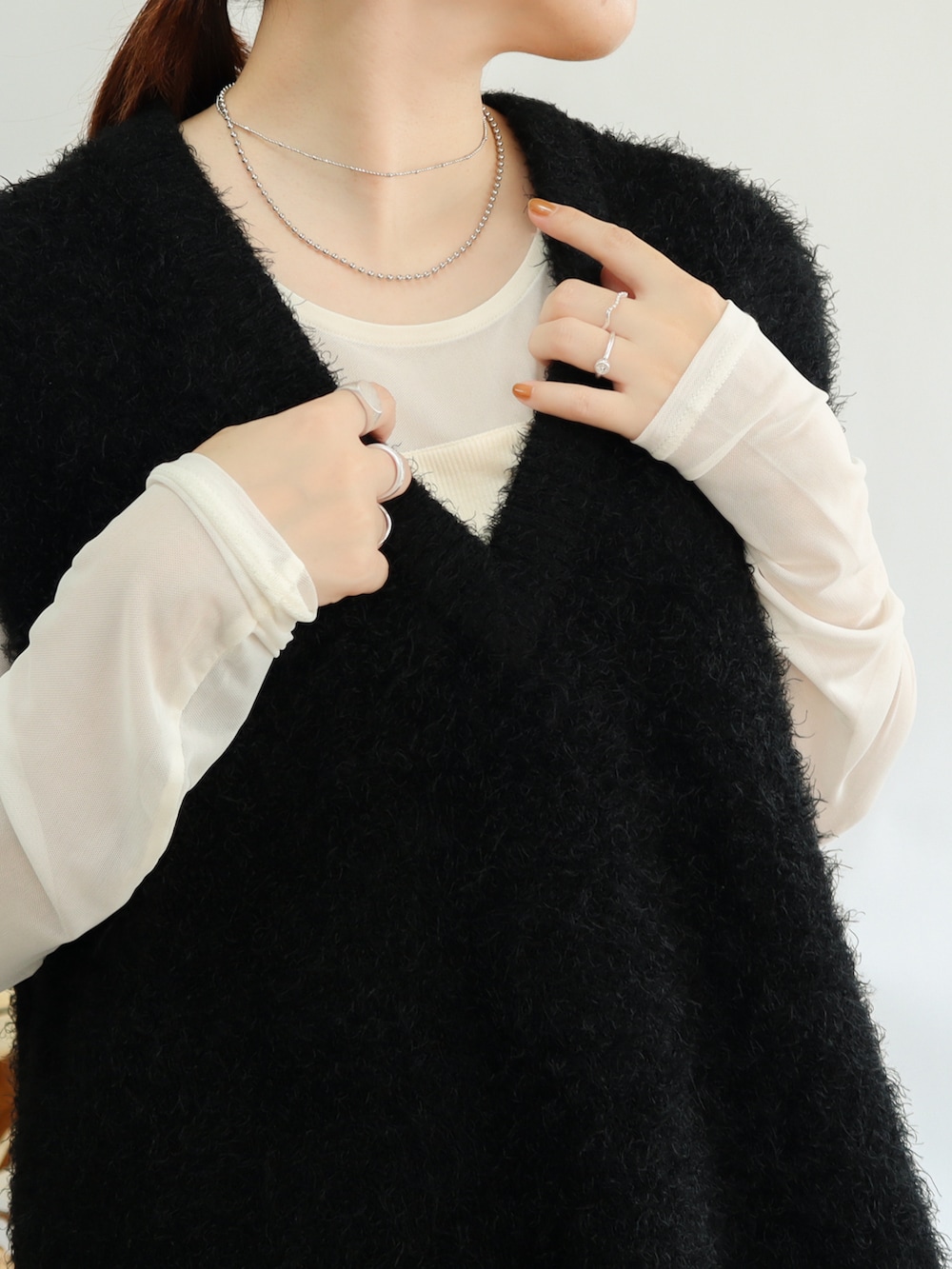 ブラック系のショルダーバッグ、グリーン系のスカート、ブラック系のブーツを着用したレディースの秋コーディネートの2枚目の写真