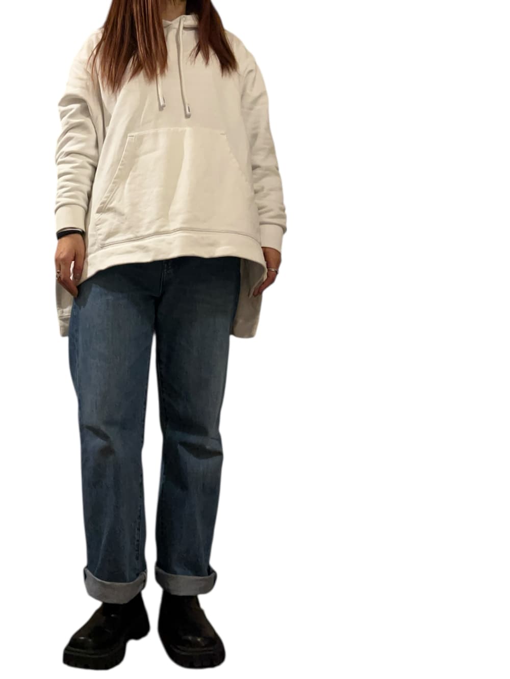 ブラック系のブーツ、ブルー系のデニムパンツ、ホワイト系のパーカーを着用したレディースの冬コーディネートの2枚目の写真