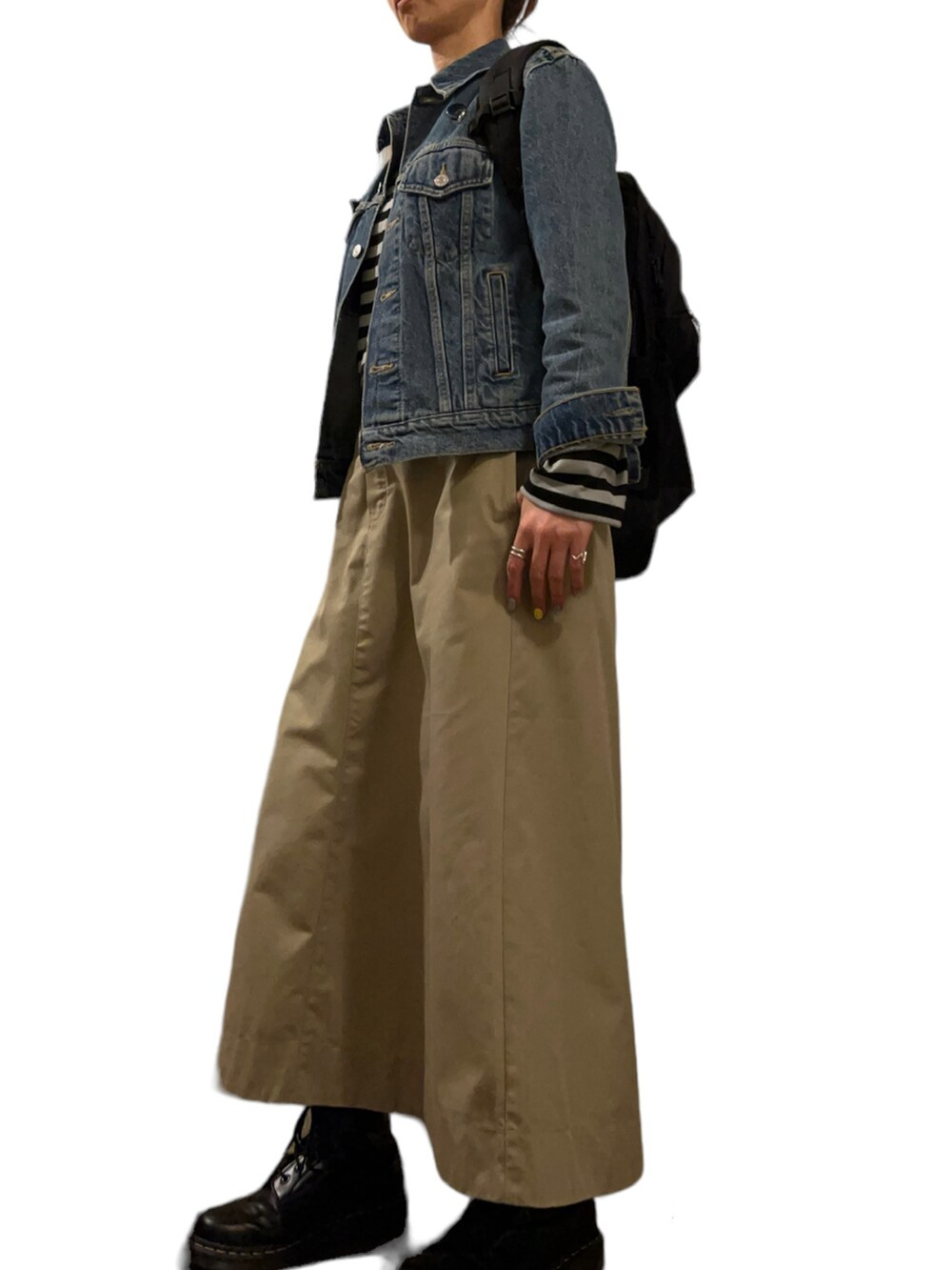 ブラック系のブーツ、ベージュ系のスカート、グリーン系のTシャツ/カットソーを着用したレディースの春コーディネートの2枚目の写真