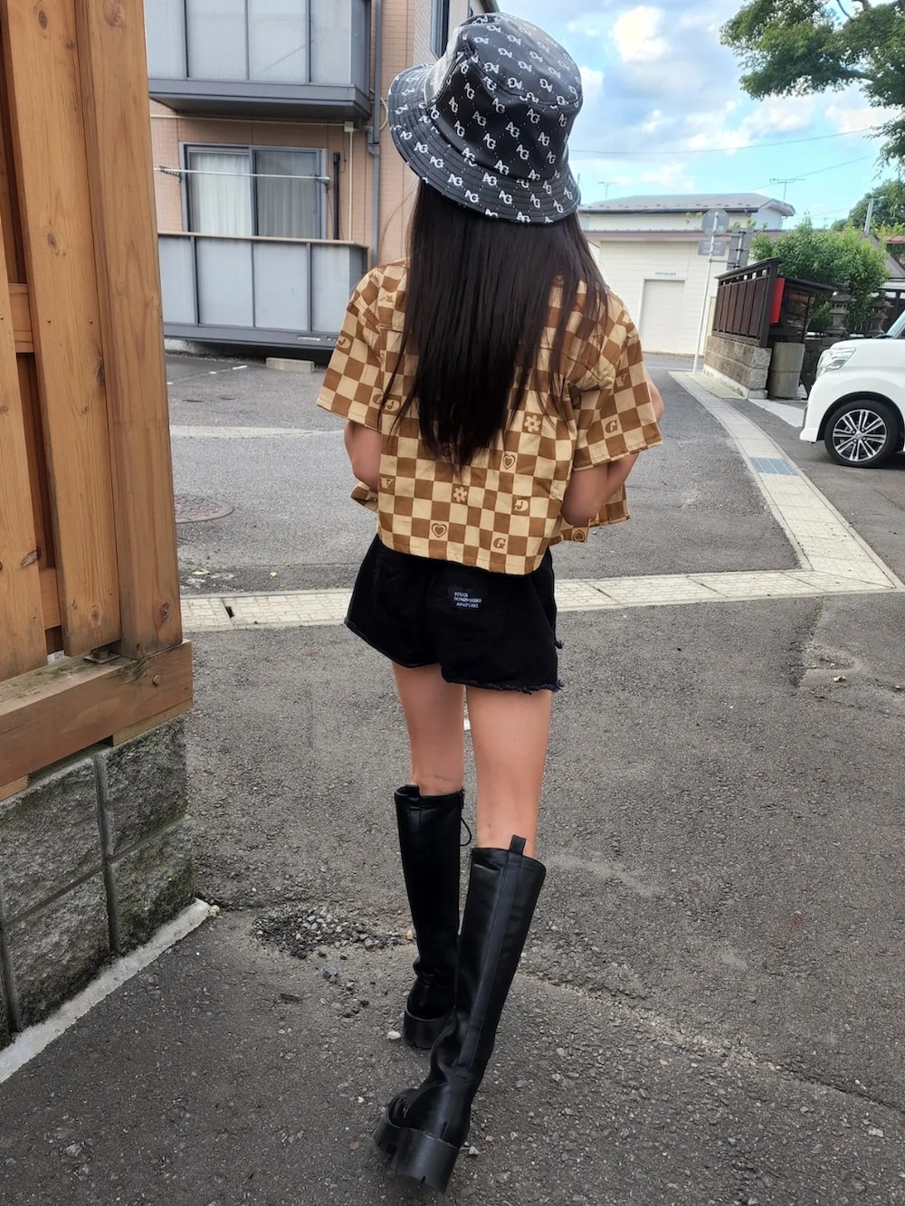ブラック系のデニムパンツ、ブラック系のチューブトップ、ベージュ系のシャツ/ブラウスを着用したレディースの夏コーディネートの2枚目の写真