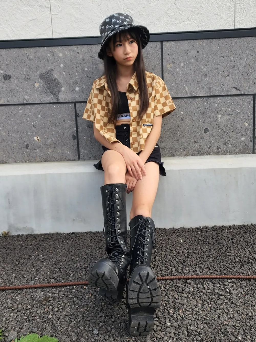 ブラック系のデニムパンツ、ブラック系のチューブトップ、ベージュ系のシャツ/ブラウスを着用したレディースの夏コーディネートの3枚目の写真