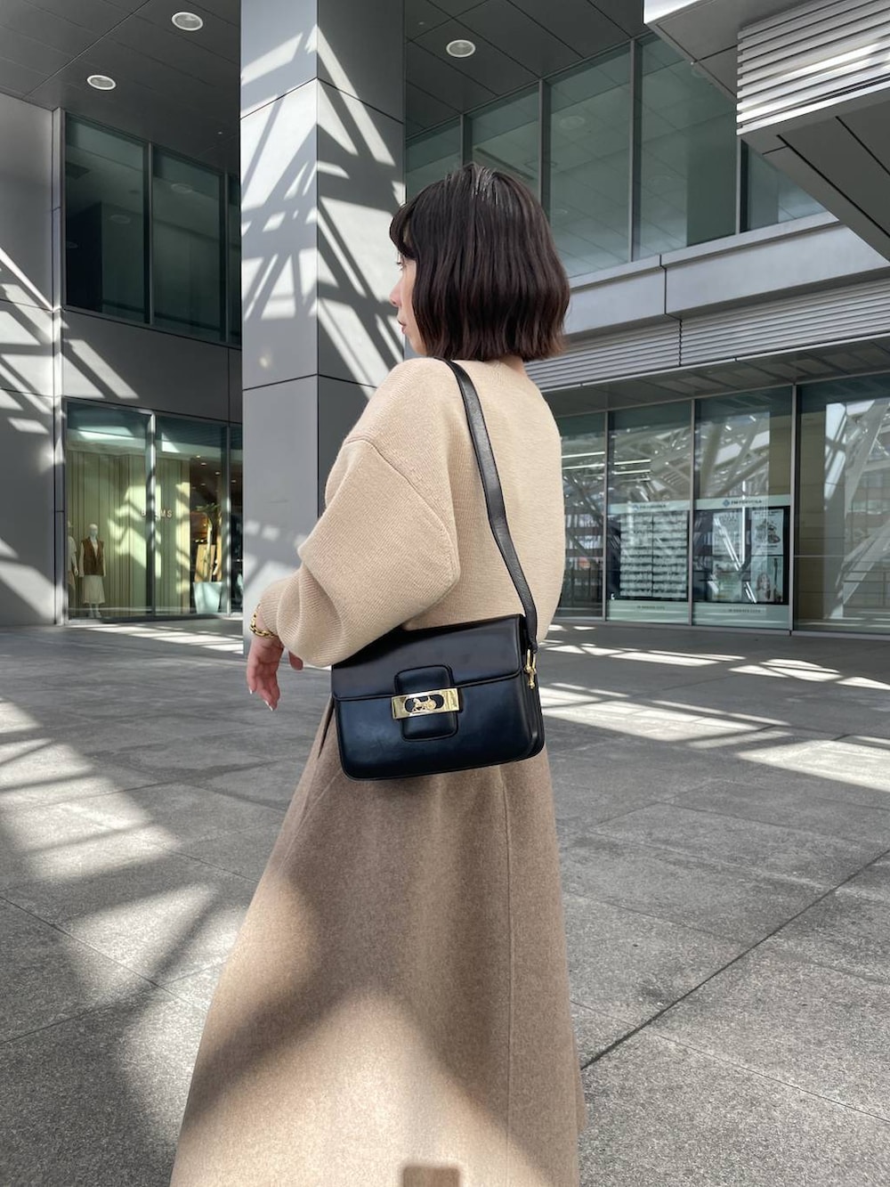 ベージュ系のニット/セーター、ベージュ系のスカート、ゴールド系のブレスレットを着用したレディースの秋コーディネートの4枚目の写真