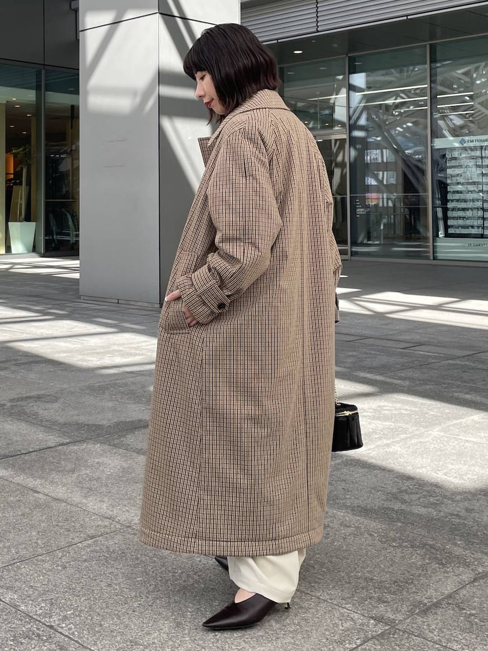 ベージュ系のTシャツ/カットソー、ホワイト系のその他パンツ、ベージュ系のチェスターコートを着用したレディースの秋コーディネートの2枚目の写真