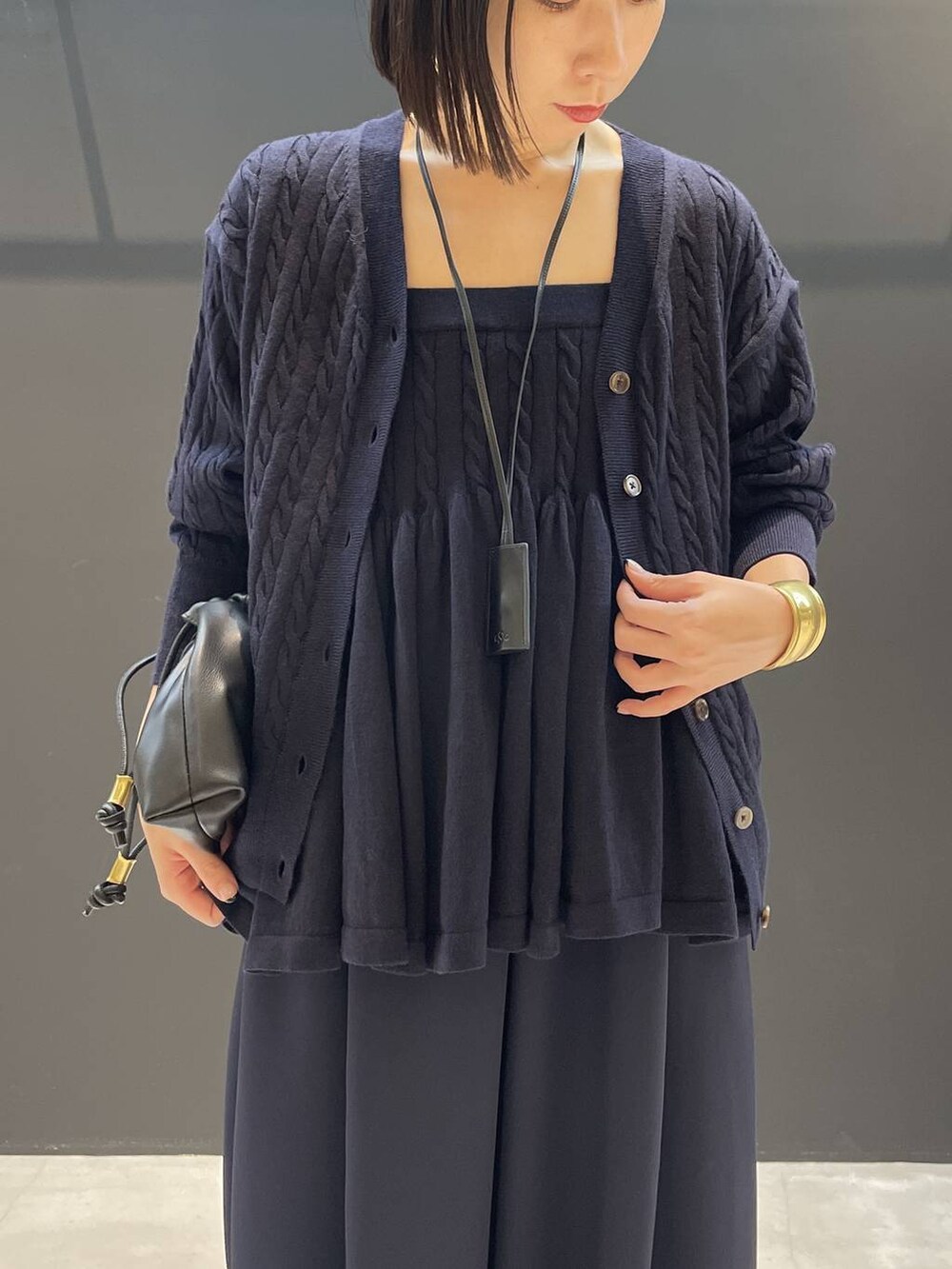 ブルー系のカーディガン/ボレロ、ブルー系のその他パンツ、ブラック系のクラッチバッグを着用したレディースの秋コーディネートの2枚目の写真