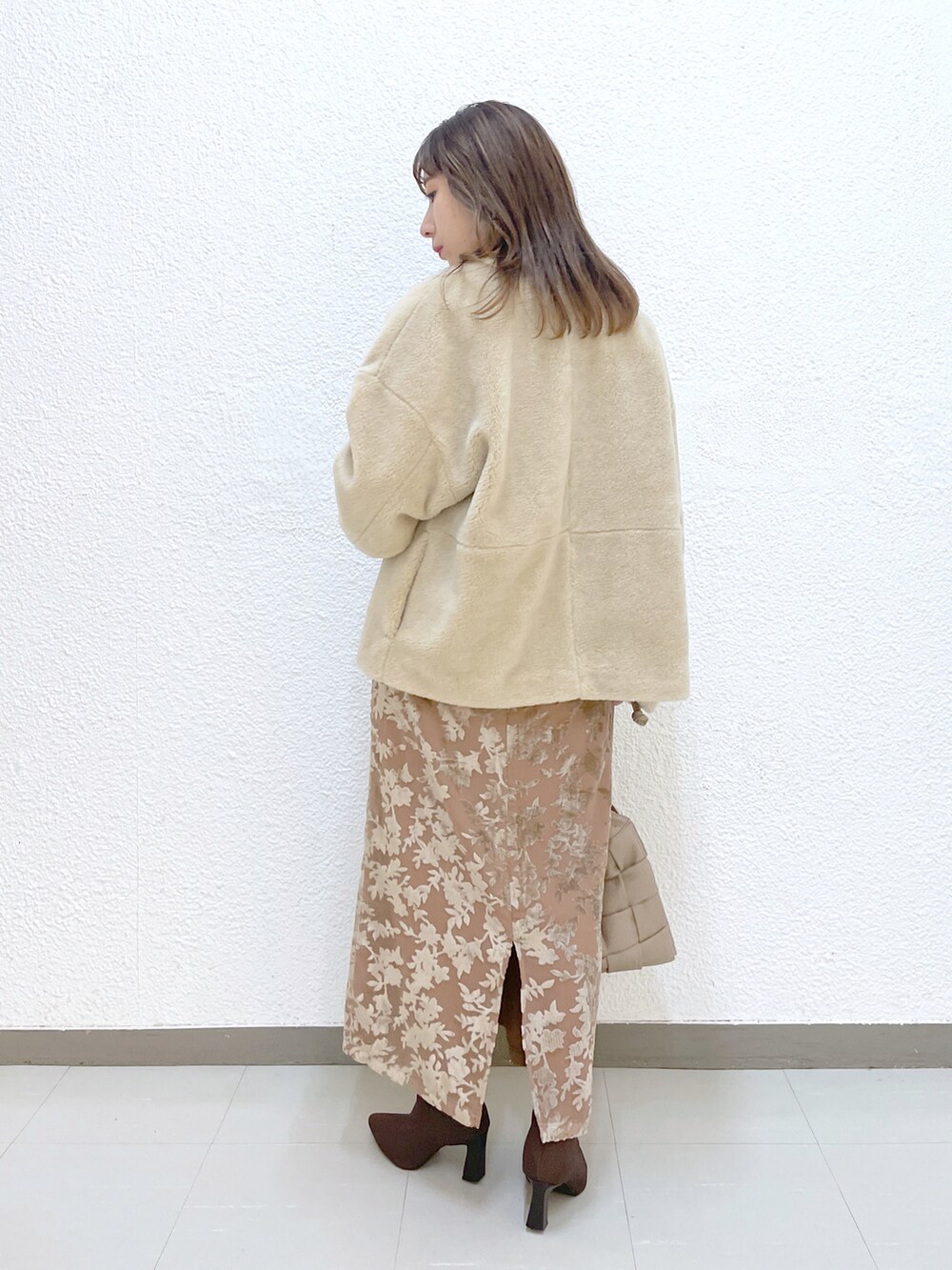 ベージュ系のブルゾン、ホワイト系のTシャツ/カットソー、ベージュ系のスカートを着用したレディースの秋コーディネートの3枚目の写真