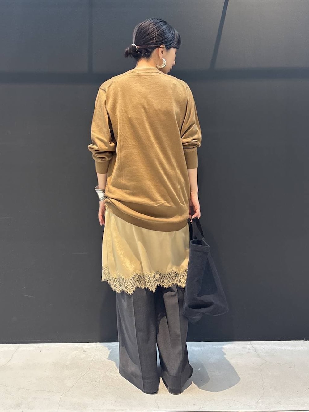 ブラック系のトートバッグ、ベージュ系のワンピース、ブラウン系のカーディガン/ボレロを着用したレディースの冬コーディネートの3枚目の写真