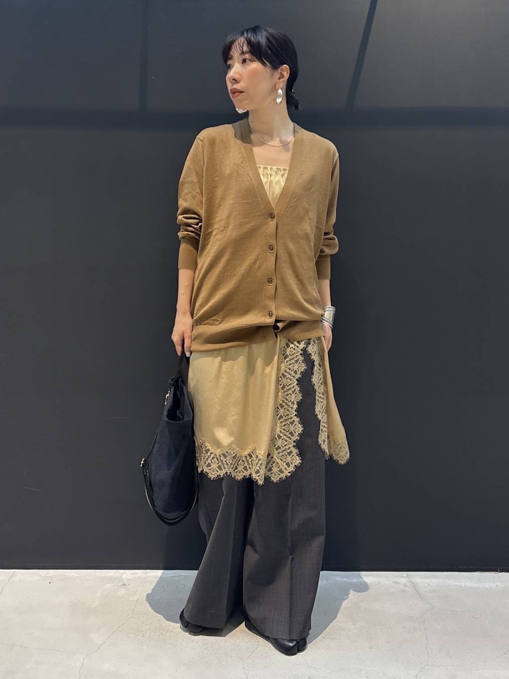 ブラック系のトートバッグ、ベージュ系のワンピース、ブラウン系のカーディガン/ボレロを着用したレディースの冬コーディネートの4枚目の写真