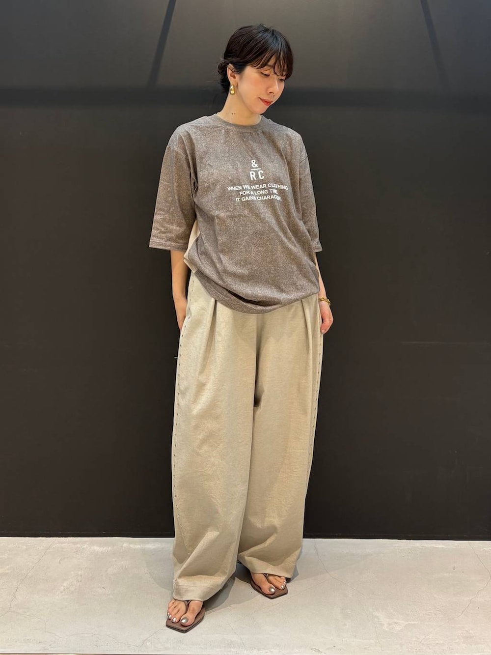 ベージュ系のその他パンツ、ブラウン系のTシャツ/カットソー、ゴールド系のピアス（両耳用）を着用したレディースの夏コーディネートの6枚目の写真