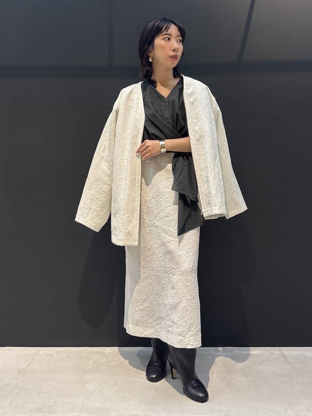 ホワイト系のスカート、グレー系のシャツ/ブラウス、ホワイト系のブルゾンを着用したレディースの冬コーディネートの4枚目の写真