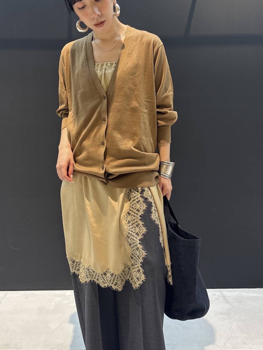 ブラック系のトートバッグ、ベージュ系のワンピース、ブラウン系のカーディガン/ボレロを着用したレディースの冬コーディネートの2枚目の写真