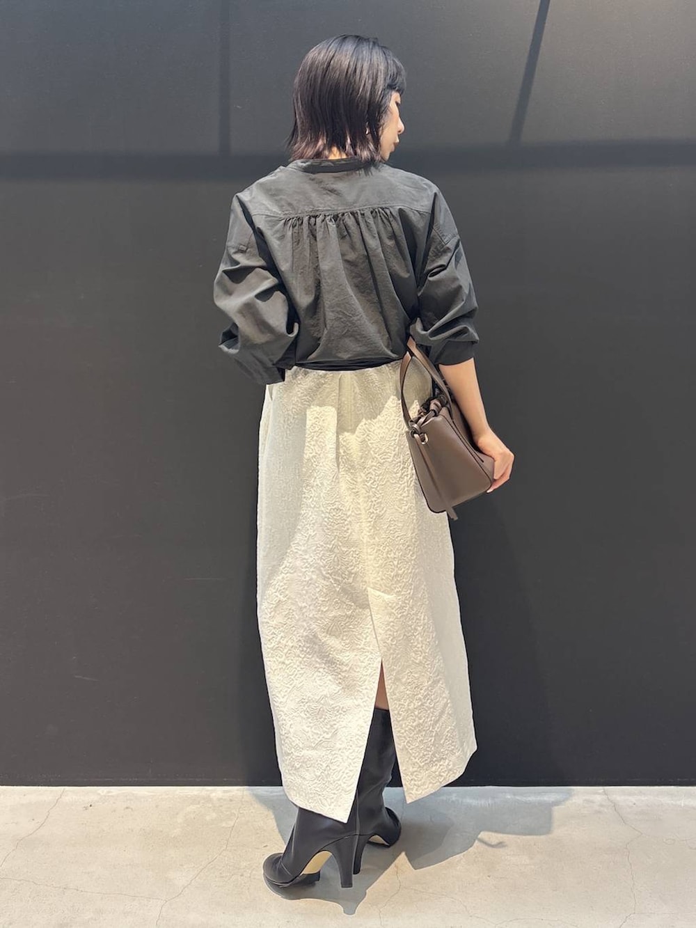 ホワイト系のスカート、グレー系のシャツ/ブラウス、ホワイト系のブルゾンを着用したレディースの冬コーディネートの3枚目の写真