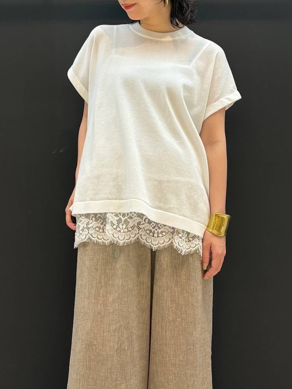 ベージュ系のその他パンツ、ホワイト系のニット/セーター、ゴールド系のバングル/リストバンドを着用したレディースの夏コーディネートの4枚目の写真