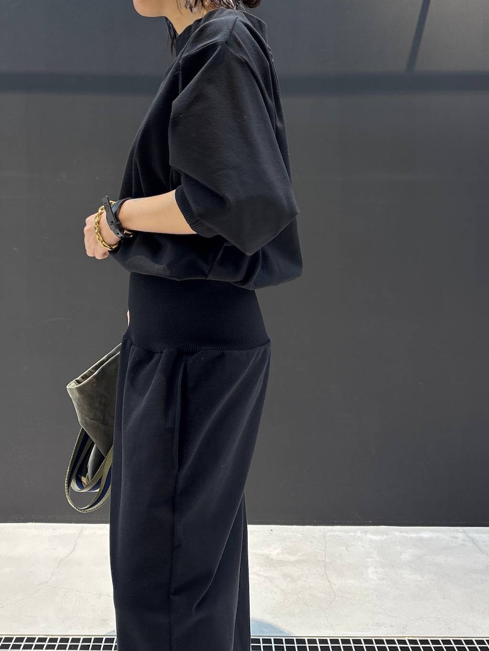 グリーン系のトートバッグ、ブラック系のワンピース、ブラック系のブレスレットを着用したレディースの冬コーディネートの2枚目の写真