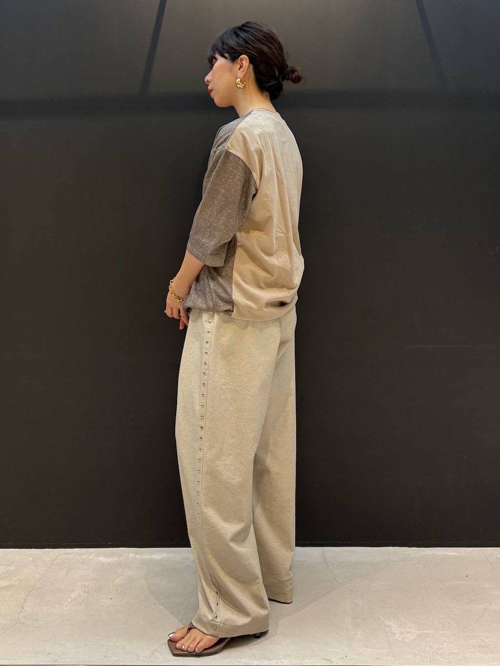 ベージュ系のその他パンツ、ブラウン系のTシャツ/カットソー、ゴールド系のピアス（両耳用）を着用したレディースの夏コーディネートの3枚目の写真