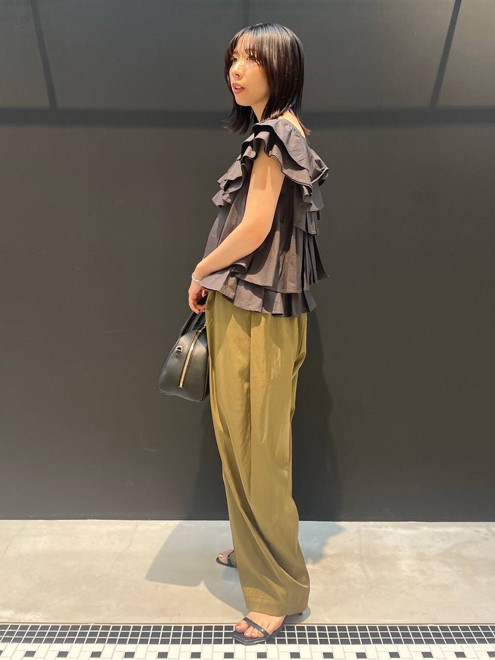 ベージュ系のその他パンツ、グレー系のシャツ/ブラウス、ブラック系のネックレスを着用したレディースの夏コーディネートの2枚目の写真