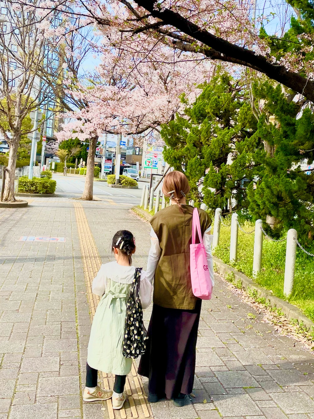 グリーン系のベスト、ブラック系のスカート、ブラック系のブーツを着用したレディースの春コーディネートの2枚目の写真