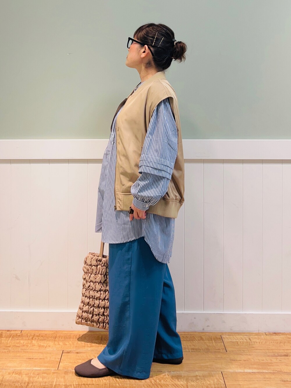 ブルー系のシャツ/ブラウス、ブラウン系のベスト、ベージュ系のバッグを着用したレディースの秋コーディネートの3枚目の写真