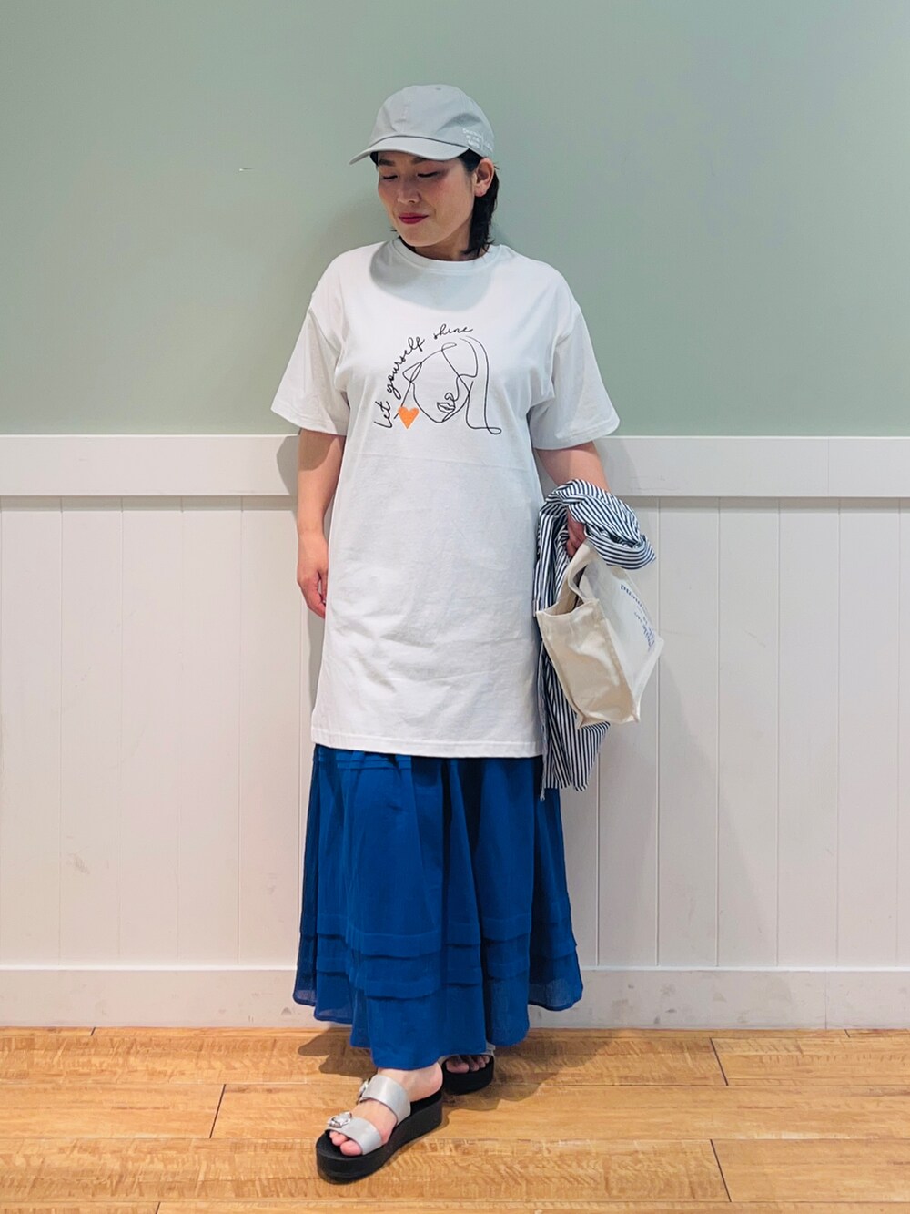 ブルー系のシャツ/ブラウス、ホワイト系のTシャツ/カットソー、ホワイト系のトートバッグを着用したレディースの夏コーディネートの3枚目の写真